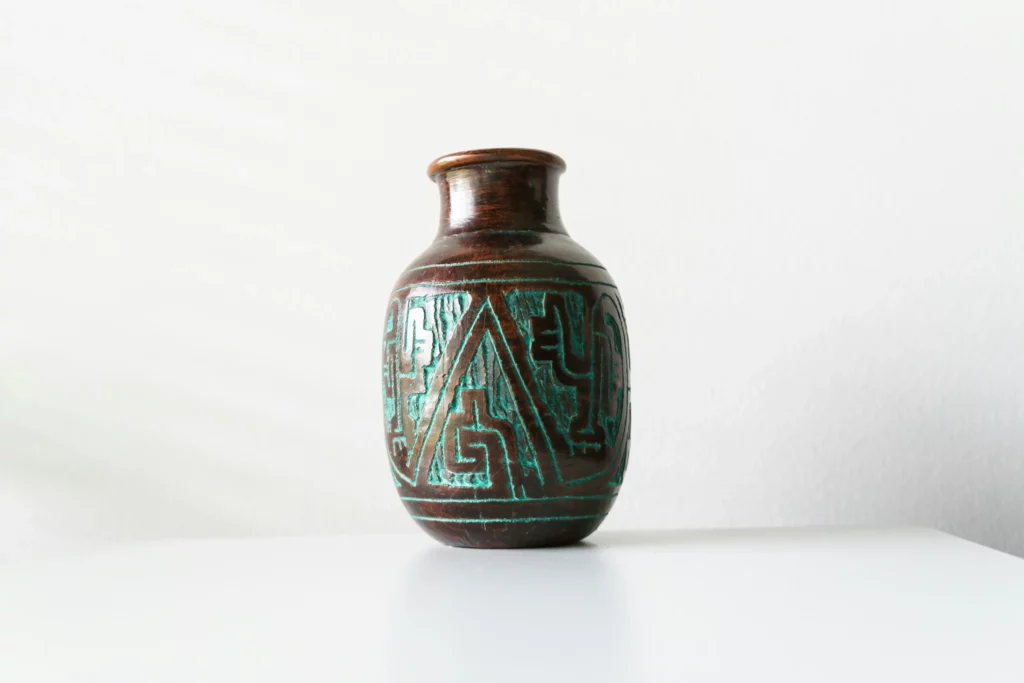 Vase en céramique brune gravé de motifs tribaux anciens.