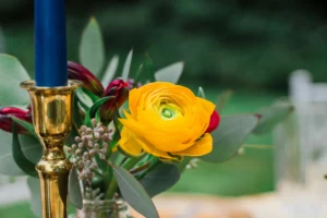 Bouquet de fleurs de renoncule jaune et bougie bleue élégante.